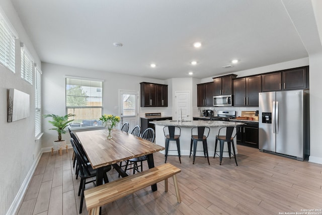 dining space featuring sink and light wood-type flooring