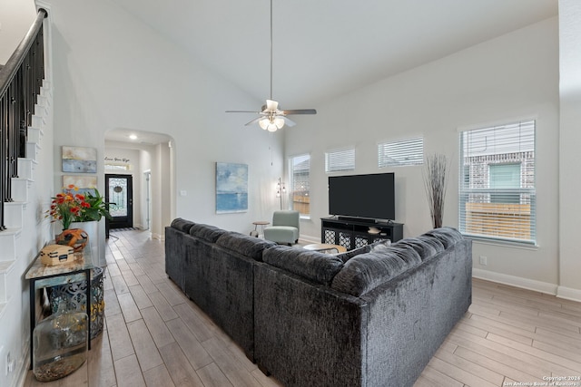 living room with ceiling fan, high vaulted ceiling, and light wood-type flooring