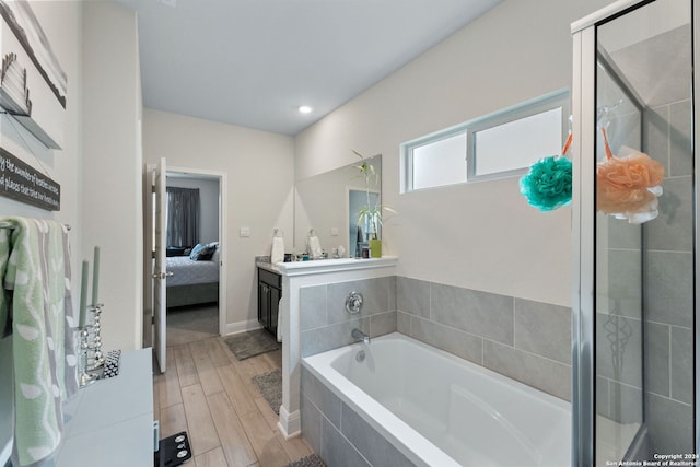 bathroom with hardwood / wood-style floors, vanity, and plus walk in shower