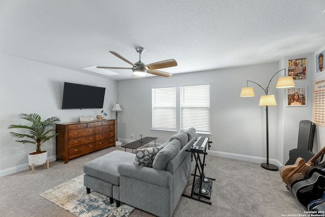 carpeted living room featuring ceiling fan and a textured ceiling