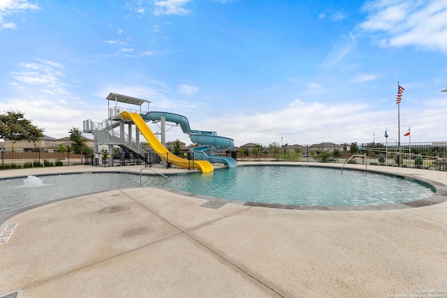 view of swimming pool with a patio area and a water slide