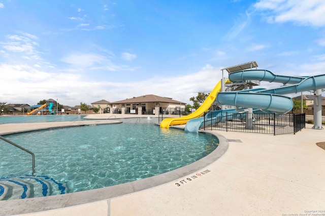 view of pool with a playground, a patio area, and a water slide