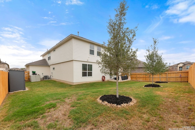 back of property with a yard, a shed, and cooling unit