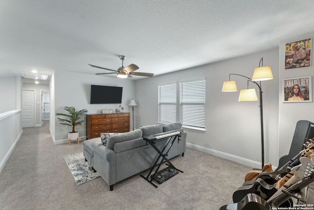 living room with a textured ceiling, ceiling fan, and light carpet