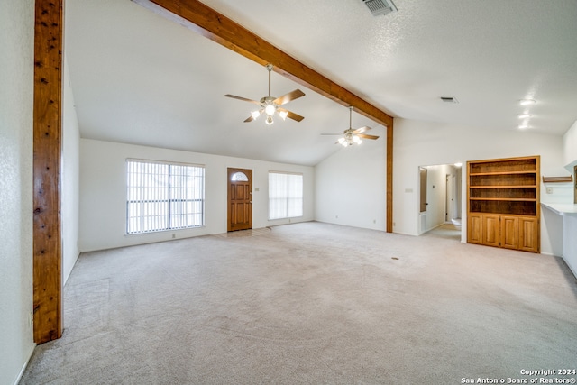 unfurnished living room featuring ceiling fan, beamed ceiling, high vaulted ceiling, and light colored carpet