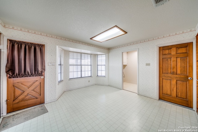 unfurnished room featuring a textured ceiling