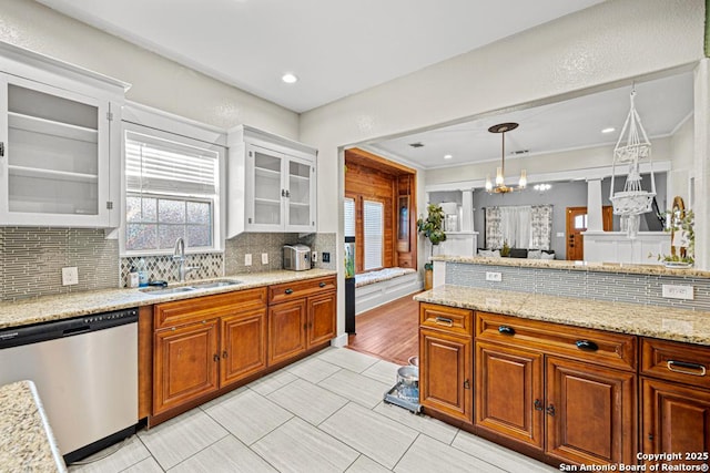 kitchen featuring pendant lighting, white cabinets, sink, stainless steel dishwasher, and a chandelier