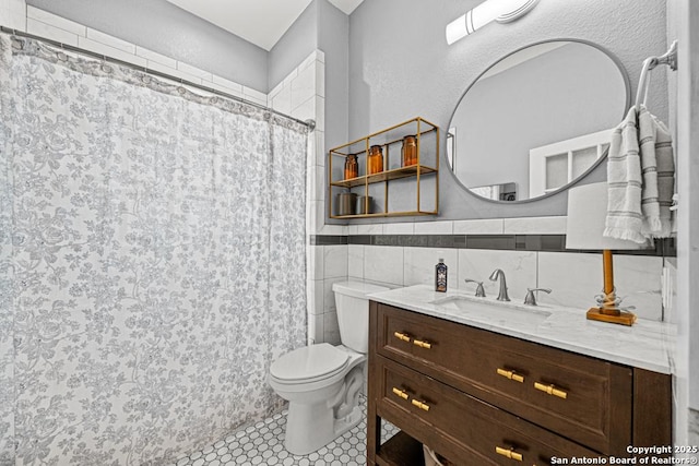 bathroom featuring tile patterned floors, vanity, tile walls, toilet, and curtained shower