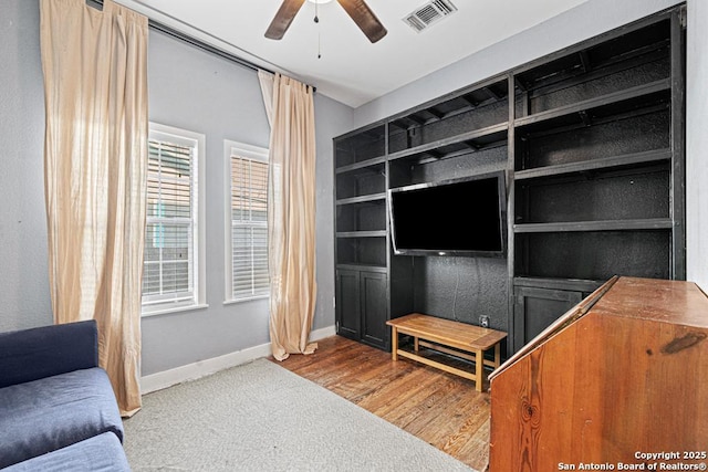 living room featuring hardwood / wood-style floors and ceiling fan