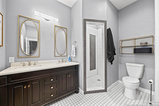 bathroom with tile patterned flooring, toilet, a tile shower, and vanity