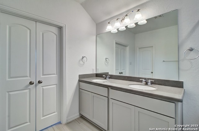 bathroom with vanity and vaulted ceiling