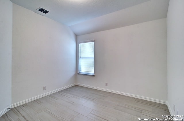 empty room with lofted ceiling