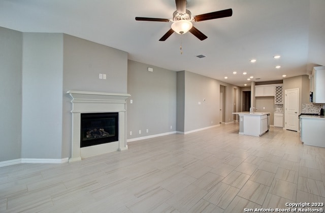 unfurnished living room with ceiling fan