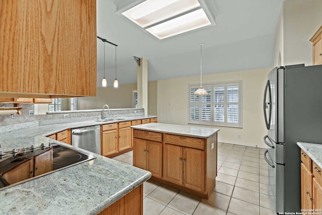 kitchen featuring a center island, light tile patterned floors, light stone countertops, appliances with stainless steel finishes, and decorative light fixtures