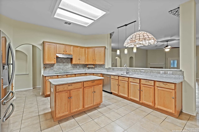 kitchen featuring sink, ceiling fan, appliances with stainless steel finishes, decorative light fixtures, and kitchen peninsula