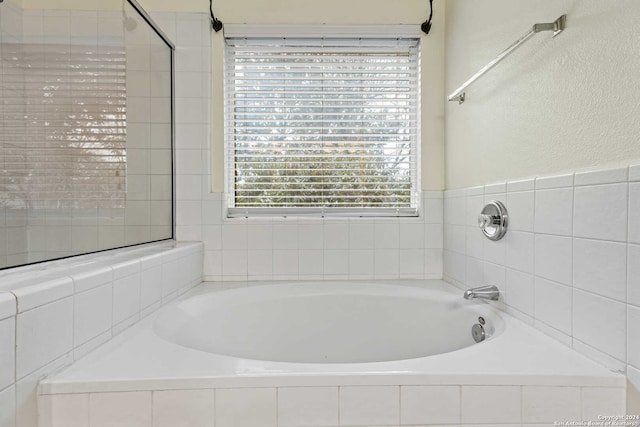 bathroom featuring a relaxing tiled tub