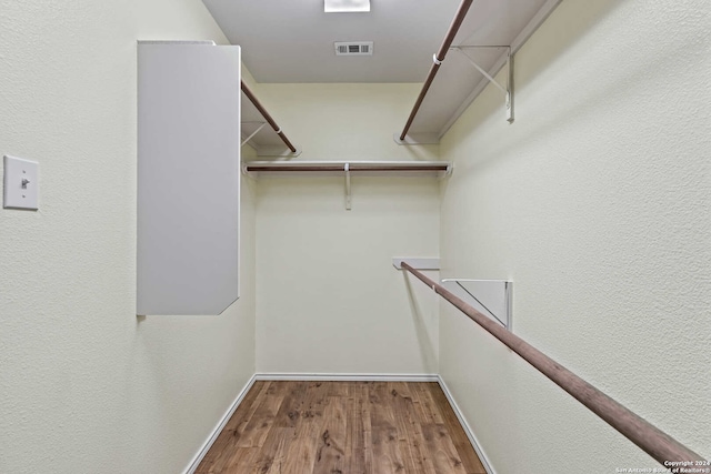 walk in closet with hardwood / wood-style floors