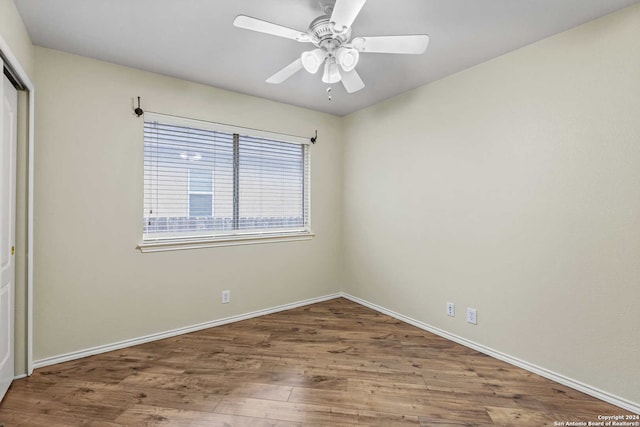 empty room with ceiling fan and hardwood / wood-style flooring