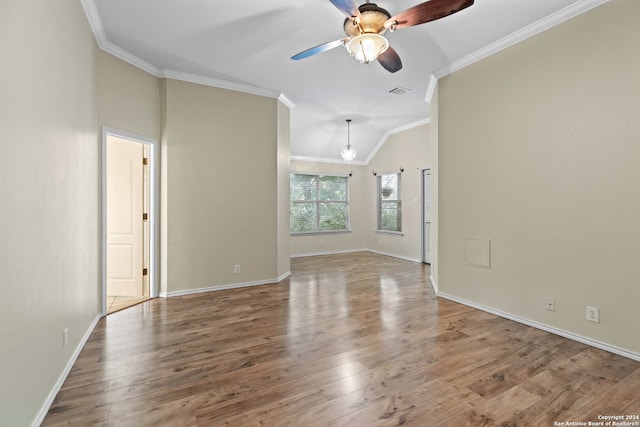 empty room featuring hardwood / wood-style floors, ceiling fan, crown molding, and vaulted ceiling