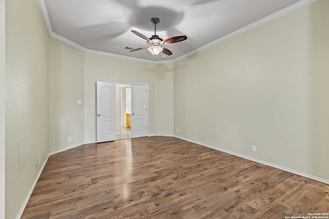 empty room featuring hardwood / wood-style flooring, ceiling fan, and ornamental molding