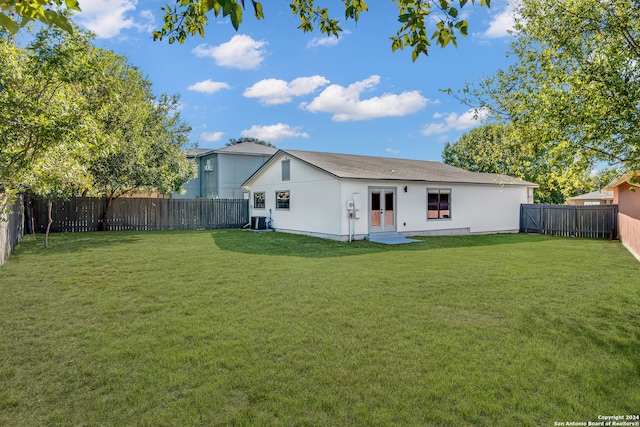 back of house with a lawn and cooling unit