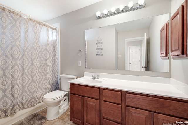 bathroom featuring tile patterned flooring, vanity, and toilet