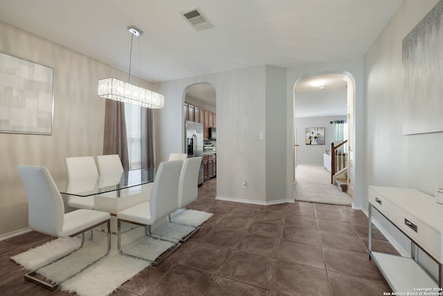 tiled dining space with a notable chandelier