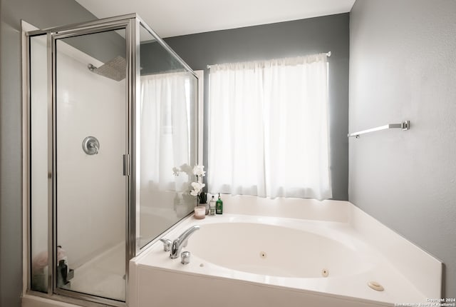 bathroom featuring a healthy amount of sunlight and separate shower and tub