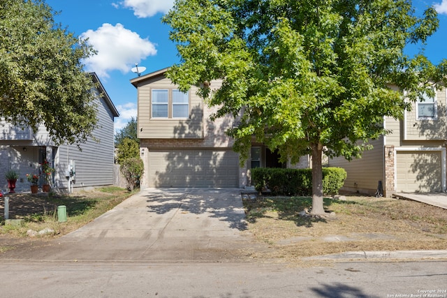 obstructed view of property featuring a garage, concrete driveway, and brick siding