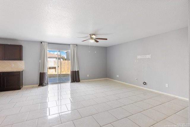 interior space featuring light tile patterned floors, a textured ceiling, and ceiling fan