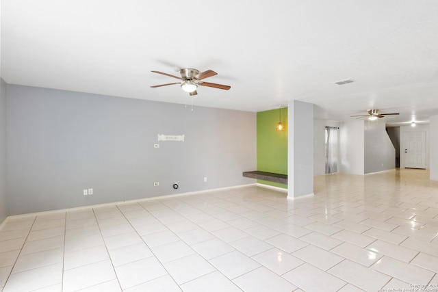 empty room featuring ceiling fan, light tile patterned floors, visible vents, and baseboards