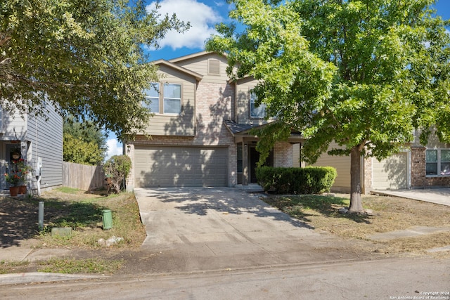 view of front of property featuring brick siding, driveway, an attached garage, and fence