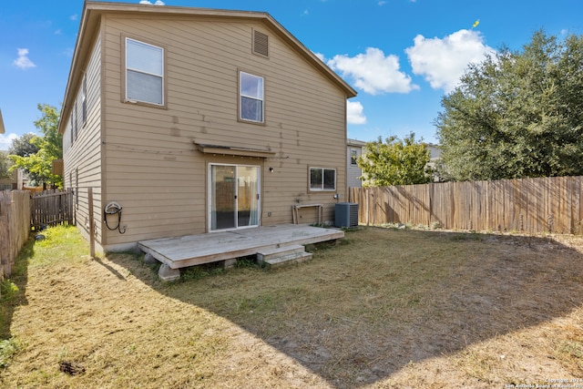 rear view of property featuring a yard, a fenced backyard, a wooden deck, and central air condition unit