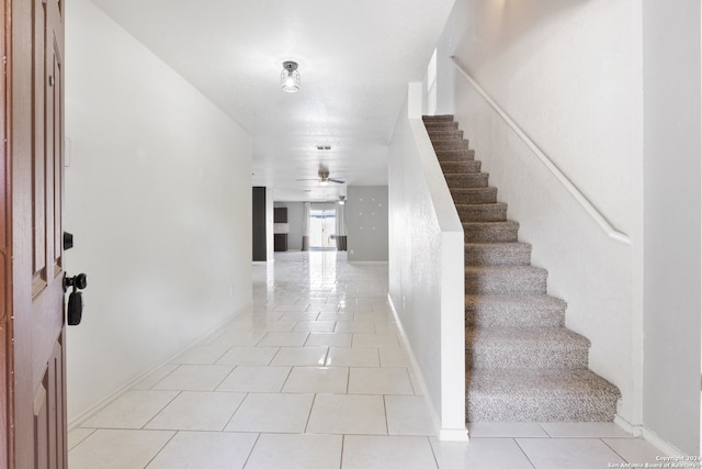 foyer featuring light tile patterned floors and ceiling fan