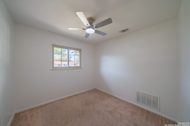 carpeted spare room featuring ceiling fan