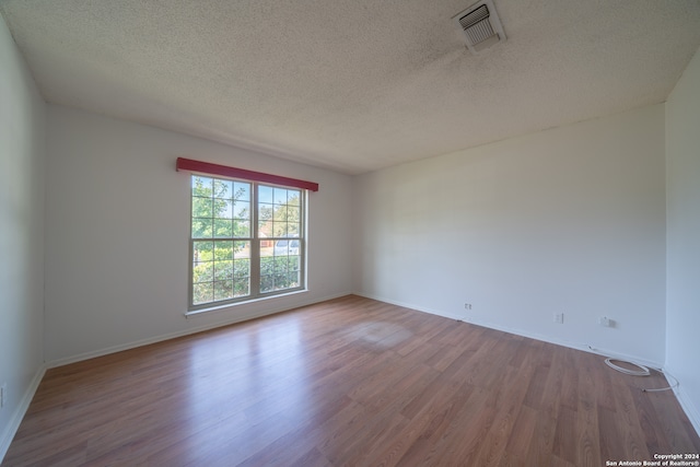 empty room featuring hardwood / wood-style floors and a textured ceiling