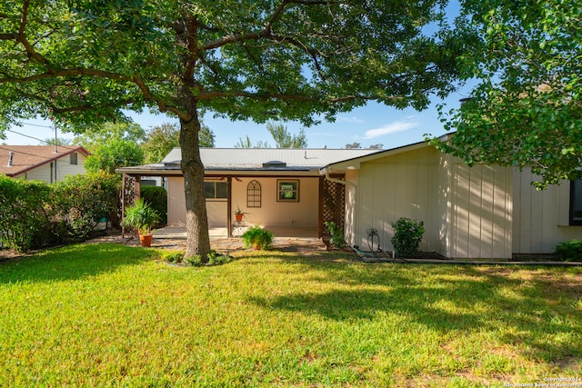 rear view of property featuring a lawn