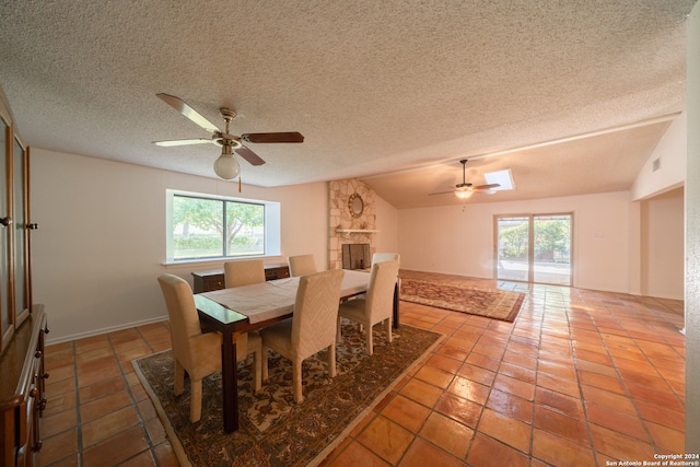 dining room featuring tile patterned flooring, a textured ceiling, ceiling fan, and lofted ceiling