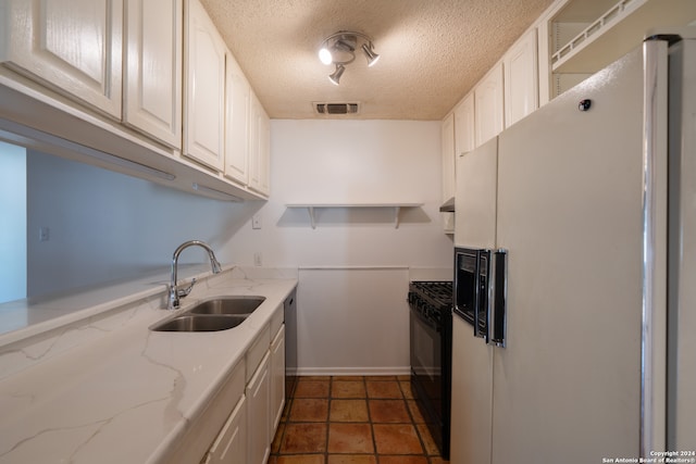 kitchen with black electric range oven, white cabinets, sink, white fridge with ice dispenser, and light stone counters