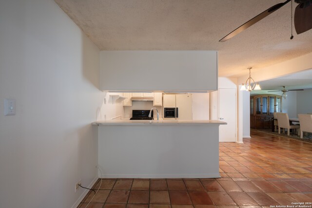 kitchen featuring black range, white fridge with ice dispenser, a textured ceiling, decorative light fixtures, and white cabinetry