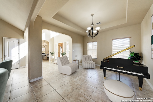 sitting room featuring a raised ceiling, a notable chandelier, and light tile patterned flooring