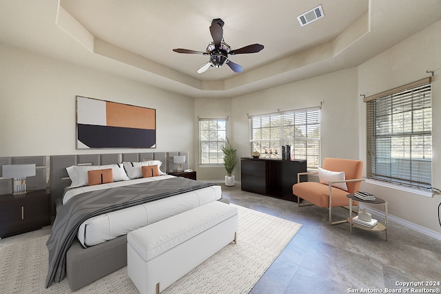 bedroom with a tray ceiling and ceiling fan