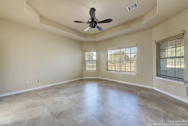 unfurnished room featuring ceiling fan and a tray ceiling