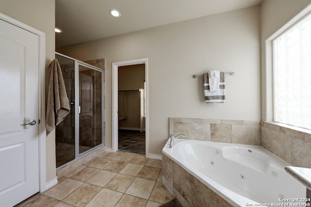 bathroom with a wealth of natural light, tile patterned flooring, and plus walk in shower