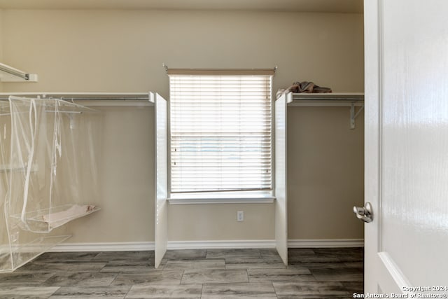 walk in closet with hardwood / wood-style flooring