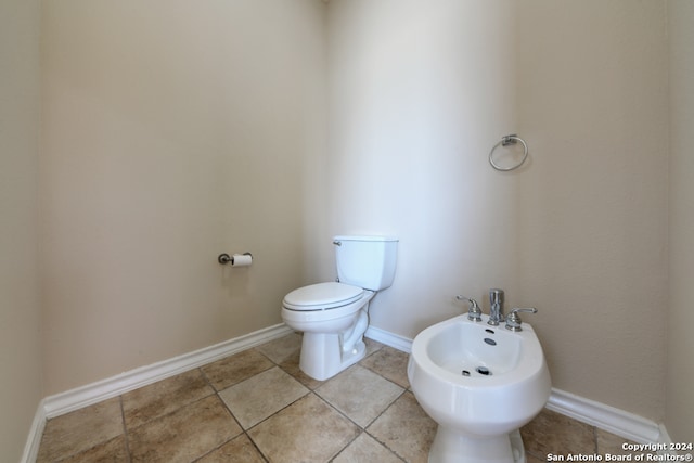 bathroom with tile patterned floors, toilet, and a bidet