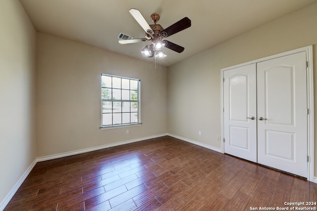 unfurnished bedroom with dark hardwood / wood-style floors, ceiling fan, and a closet