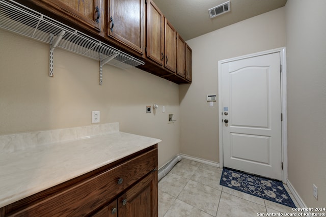 laundry area with hookup for an electric dryer, cabinets, light tile patterned floors, and washer hookup