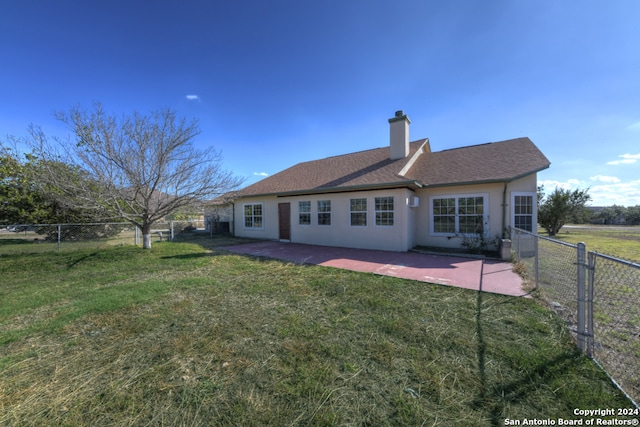 rear view of property featuring a yard and a patio area