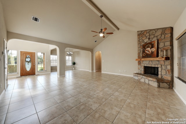 unfurnished living room featuring ceiling fan, beam ceiling, a stone fireplace, and light tile patterned flooring